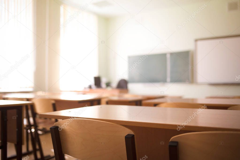 School classroom in blur background without young student. Blurry view of class room no kid or teacher with chairs and tables in campus.