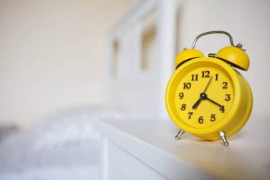 Yatak odanın iç arka planda komodinin üzerinde sarı alarm saat ayakta. yedi saat 20 dakika