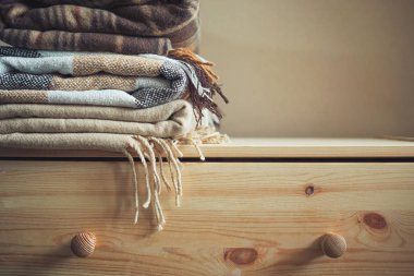 bej renkli damalı yün yığın üzerinde tahta bir sandık battaniye. Sonbahar - Kış kavramı ev sıcaklık ve konfor. tonda, kopya alanı