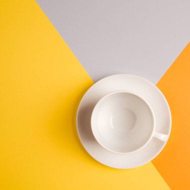 parlak sarı-turuncu-bej-gri arka plan üzerinde beyaz boş kahve fincanı. kopya spase, düz yatıyordu. Sonbahar Cafe menü kavramı