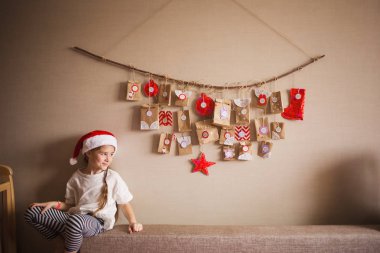 duvarda asılı varış takvimi. çocuklar için küçük hediyeler sürprizler. sağa doğru seyir kız.