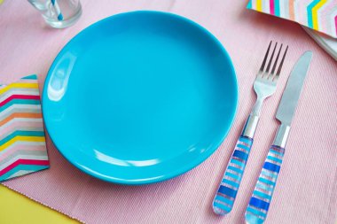 boş tabak ve çatal bıçak takımı, pembe arka plan mavi. yiyecek hazırlama kavramı.