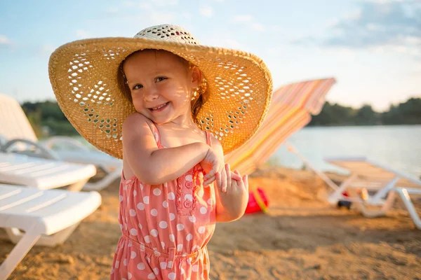 şezlonglar, kum ve su arka plan üzerinde şapkalı beach.girl seksi bebek. Çocuklu tatil yaz.