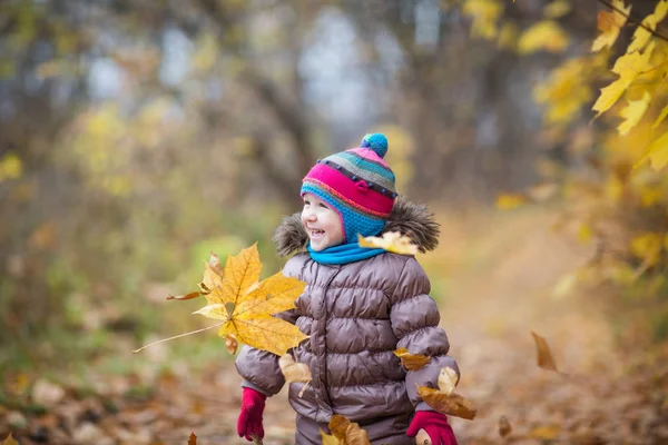 Fröhliches kleines Kind, kleines Mädchen lacht und spielt Blätter im Herbst auf dem Naturspaziergang im Freien — Stockfoto