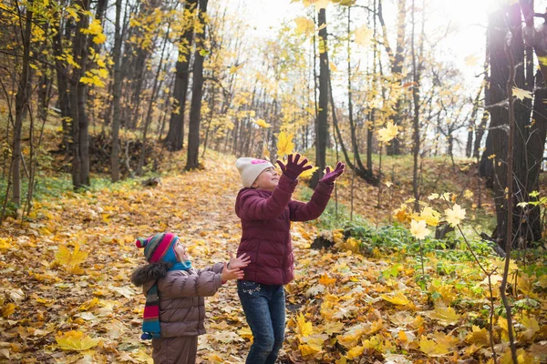 Happy little children laughing and playing leaves in the autumn on the nature walk outdoors. life style — Stock Photo, Image