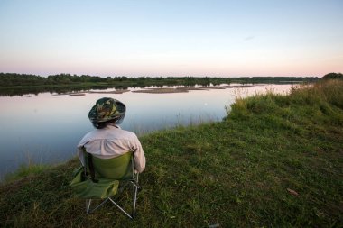 Tek başına açık hava aktiviteleri. Kendini soyutlama. Nehir kıyısında dinlenme. Açık havada tatil. seyahat koronavirüsü.