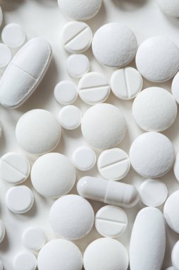 Beyaz zemin üzerinde çeşitli şekillerde tabletler üst görünümü kapatın. Minimalist ilaç ve tedavi kavramı.