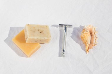 Çelik traş bıçağı, sabun, kabuk, beyaz arka planda.