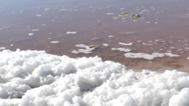 Torrevieja Tuz Gölü ve sahilde tuz köpük. Portakal suyu, beyaz köpük ve mavi gökyüzü.