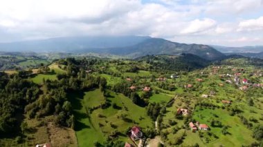 Kuşlar kenti Transilvanya dağlar Romania.Bran, Kont Drakula Kalesi göz. Dağlık eski binalar üzerinde casus uçak uçar. Çevresinde yeşil çayır ve orman. Işık bulutlar dağlar başında kapak. 