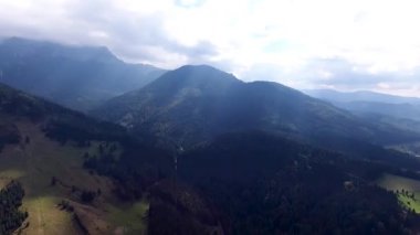 Kuşlar kenti Transilvanya dağlar Romania.Bran, Kont Drakula Kalesi göz. Dağlık eski binalar üzerinde casus uçak uçar. Çevresinde yeşil çayır ve orman. Işık bulutlar dağlar başında kapak. 