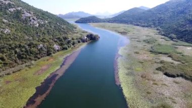 Havadan görünümü Crnojevic Nehri. küçük dağlar ve tepeler arasında nehir akar. Bu tamamen yeşil çekici ile büyümüş.