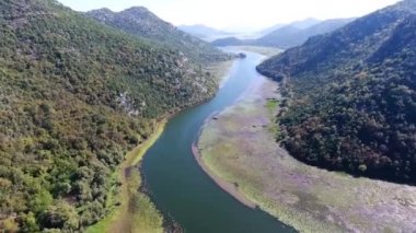 Havadan görünümü Crnojevic Nehri. küçük dağlar ve tepeler arasında nehir akar. Bu tamamen yeşil çekici ile büyümüş.