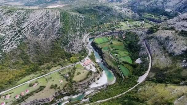 鳥瞰的にモンテネグロで Moraca 川の峡谷 オバチは道路に沿って山と川の間 白い石の岩に囲まれた 両側の木々 の生い茂った 山青い川の流れの乱流 — ストック動画