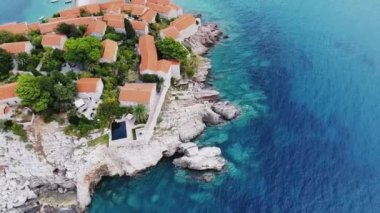 Ada, St. Stephen üzerinden bir kuş bakışı. Adriyatik Denizi. Uçak 100 metre yükseklikten şehir, evler, dağlar ve deniz olan bağlantı noktasını kaldırır. Aziz Stefan Adası oteller ile. Karadağ. Deniz Körfezi