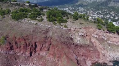 Sutomore city, Hay-Nehay kale kuş uçuş yüksekliği. Drone Denizi'nin kıyısında uçar. Antik kalıntılar ve sahilde kırmızı kayalar. Deniz ve şehir manzarası.