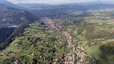 Kuşlar Transilvanya dağlarının görünümü göz. Kepek şehir. Dağlık eski binalar üzerinde casus uçak uçar. Açık gökyüzü. Evlerin vadilerde yer alır ve tüm aynı tarzda inşa edilir. Çevresinde yeşil çayır ve orman.