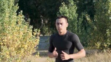 Parkta genç bir sporcu boksörü ve geri dönüş eğitimi. Genç adam tekme tekniği çalışır