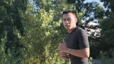 Parkta genç bir sporcu boksörü ve geri dönüş eğitimi. Genç adam tekme tekniği çalışır