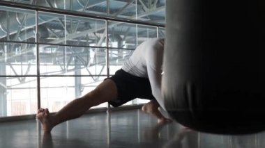 Genç bir Asyalı kickboks spor salonunda eğitim alıyor. Isınmak. Kickboxer atlet aktif çeşitli kabukları kullanarak spor salonunda sert eğitim öncesi ısınma