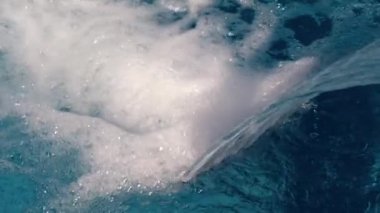 Açık gökyüzünün altında havuzda şelale yakın çekim. Su yavaş yavaş havuza düşüyor. Gökyüzü, akşam, güzel arka plan. Arkadan aydınlatmalı mavi su.