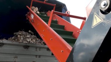 Kalın dalları kesen otomatik bir helikopter. Nakliye araçlarına otomatik malzeme sağlayan Crusher dalları. Yavaş çekim.