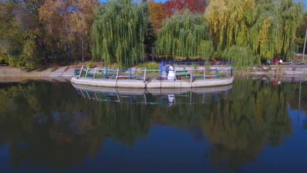 Νιόπαντροι Κοντά Στη Λίμνη Φθινόπωρο Ένα Drone Πυροβολεί Ένα Ζευγάρι — Αρχείο Βίντεο