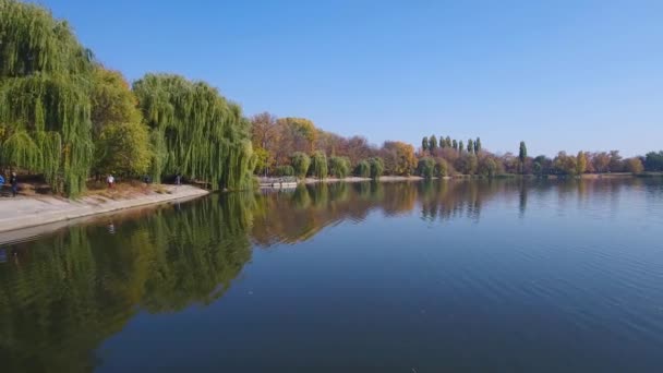 L'étendue tranquille du lac d'automne. Un drone survole lentement le lac. Les arbres d'automne sur le rivage virent au jaune. Ciel dégagé. Ville Vatutino, Ukraine .
