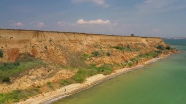 Yuzhny Odessa limanı yakınlarındaki Karadeniz 'in sarp kıyısı kuş bakışı. İHA saldırısı. 2020 yazında. Denize yakın 30 metre yüksekliğinde bir uçurumu olan kumsal. Çimler güneşin altında kurudu. Kavurucu güneş ve açık gökyüzü.