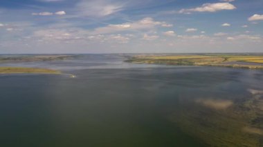 Odessa bölgesindeki Tiligul halklarının yüksek voltajlı elektrik hatları kuş bakışı. Geniş bir nehirde, bulutlar sakin havada suyun pürüzsüz yüzeyine güzel bir şekilde yansıtılır. Yüksek voltaj kabloları için yüksek demir yapılar.