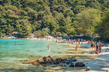 Thassos Yunanistan, 11 Eylül 2019: Güneşli bir günde Thassoss adasındaki mermer plaj turistleri deniz kenarında dinlenirken eğleniyorlar