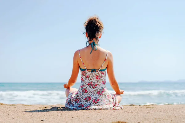 Молодая Женщина Летнем Платье Практикует Йогу Медитируя Пляже Моря Океана — стоковое фото