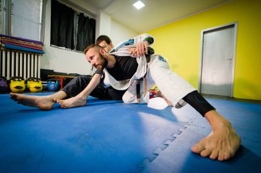Brezilya jiu jitsu BJJ eğitiminde omo plata pozisyonunda iki sporcunun kimono giyerek sondaj pozisyonu almasına izin veriliyor.
