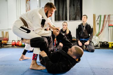 Brezilyalı Jiu JItsu BJJ profesörü gardiyan pozisyonundan öğrencilerine dövüş sanatları akademisinde eğitim dersi veriyor.