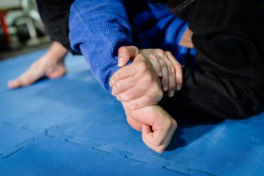 Brezilyalı Jiu jitsu BJJ jiujitsu antrenman antrenmanı sporcusu kimura ya da americana omuz kilidi takarak rakibine teknik antrenman sırasında boyun eğiyor.