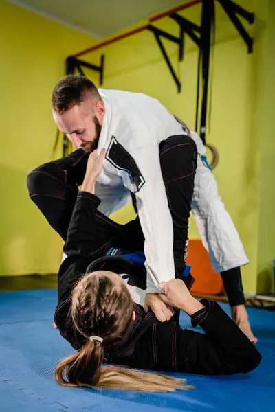 Genç Bjj çifti erkek ve kadın dövüş sanatları eğitimi alan Brezilya jiu jitsu jiujitsu eğitmeni akademide siyah beyaz kimono gi guard tasması ve kollu
