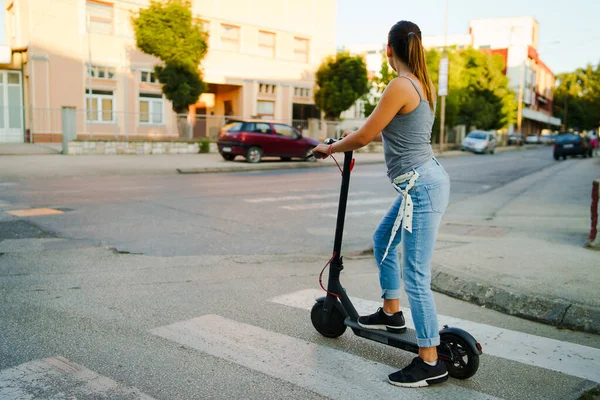 Młoda Kobieta Jeździ Elektrycznym Hulajnoga Ulicy Czeka Skrzyżowaniu Dżinsach Letni — Zdjęcie stockowe