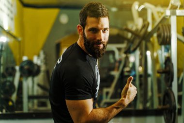 Spor salonu manzaralı beyaz bir gencin portresi.