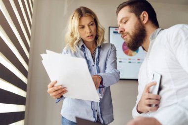 Beyaz güzel bir kadın, iş arkadaşına belgelerini gösteriyor.