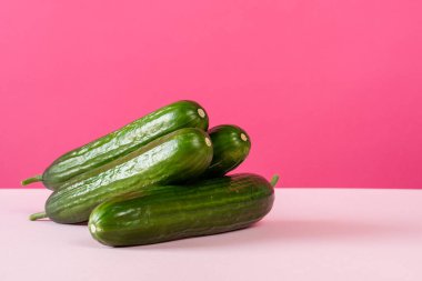 Pembe arka planda olgun salatalıklar ön görünüm kopyalama alanı natürmort hayat