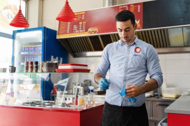 Fast food girişimcisi iş yerinde koruyucu eldivenler takıyor Kafkasyalı adam günlük hijyen öngörüsü için hazırlanıyor hastalık sorumluluk kavramından hijyen önleme yeni normal