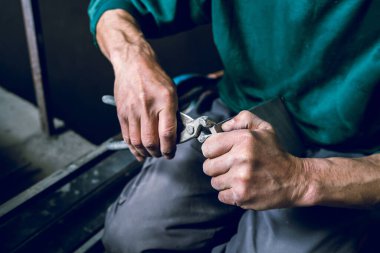 İnşaat işçisinin banyoya döşeme için seramik fayanslar keserken kullandığı aleti kapatın.