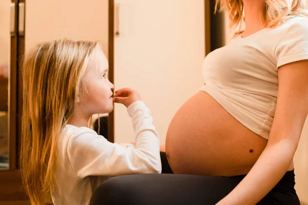 Klein Meisje Thuis Staat Bij Moeder Zwangere Vrouw Wachten Opgewonden — Stockfoto