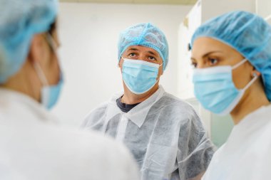 Kafkasyalı doktorlar veya hastanedeki veya laboratuvardaki bilim adamları - koruyucu ekipman maskesi takan erkek ve kadın insanlar ve kabarık başlık - koruma ve çözüm kavramı