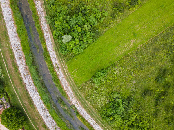 Timok river curve flow by the agriculture field and green woods - aerial top down view in spring day - Europe Serbia