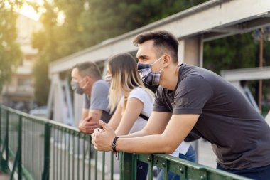 Covid-19 salgını sırasında koruyucu maskeli arkadaşlardan oluşan bir grup - Milenyum erkeği ve kadını Coronavirus 'un sonuçlarından endişe duyuyorlar - yeni normal arkadaşlık yaşam tarzı kavramı