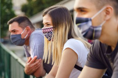 Group of caucasian millenialls tourists on the vacation wearing protective masks - Social distancing and precaution due to covid-19 pandemic - caucasian friends close up new normal lifestyle concept clipart