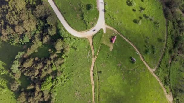 車の緑の草や木々の周りに家の緑の芝生と山脈の国の道路上から空中の景色 ヨーロッパセルビアのStara Planina Old Mountainでの自然旅行のコンセプトドローン写真 — ストック動画