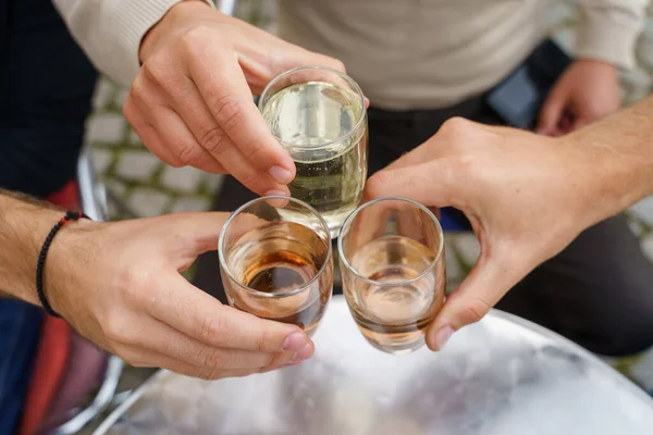 知られざる人々の手を握り合うグラストースト バルカン諸国で人気のワインとソーダアルコール飲料価格で祝う白人男性 屋外での一番上の眺め — ストック写真