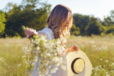 Beyaz elbiseli beyaz bir kızın tarlada yürümesi, yaz gününde elinde çiçekler, şapkasında güzel bir kadın, yarım ömürlük yalnızlık, reddedilme kavramı.